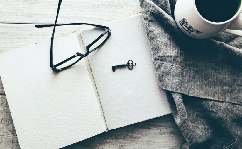 eyeglasses and skeleton key on white book